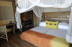 Comfy bed inside a Dolomite Camp bush chalet Etosha National Park